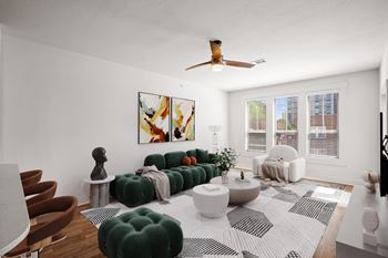 A living room with a green sofa and a white rug. at Mirabelle Luxury Apartments, Kansas City